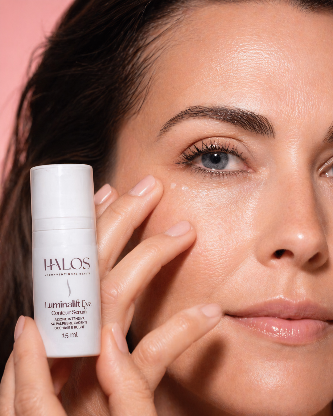 Donna che massaggia il contorno occhi tenendo Luminalift Eye Contour Serum