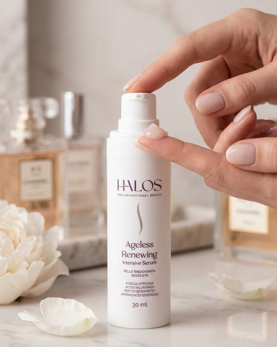 Mano che eroga Ageless Renewing Intensive Serum dal flacone airless
