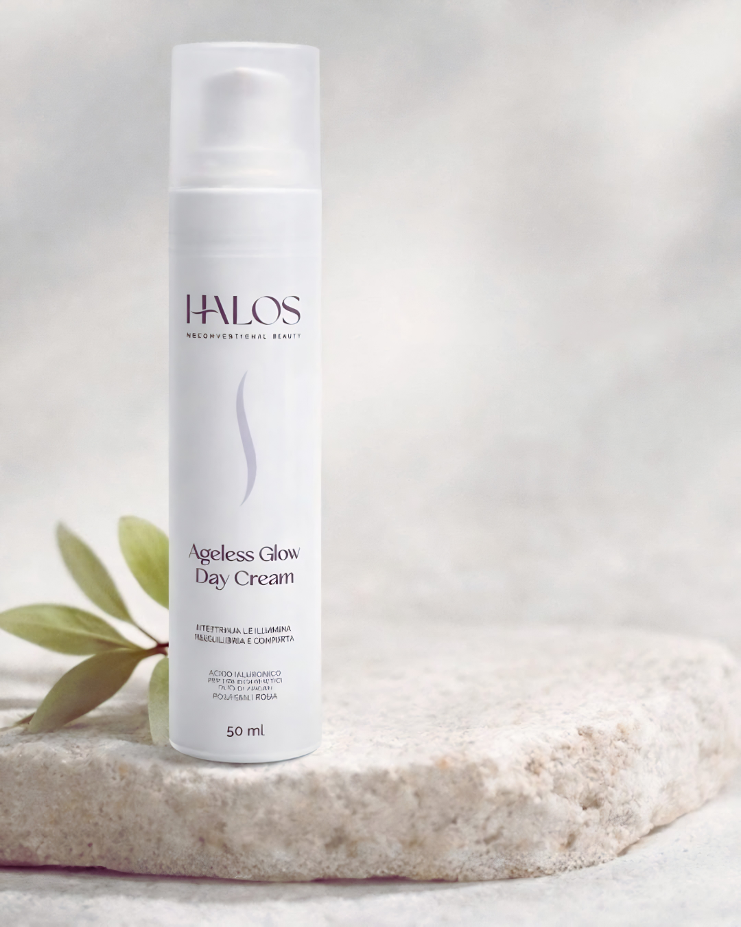 Flacone airless di Ageless Glow Day Cream Halos su una base in pietra chiara