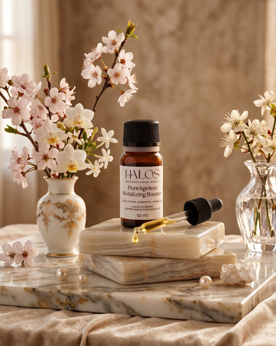 Flacone e contagocce di PureAgeless Revitalizing Booster in una composizione floreale