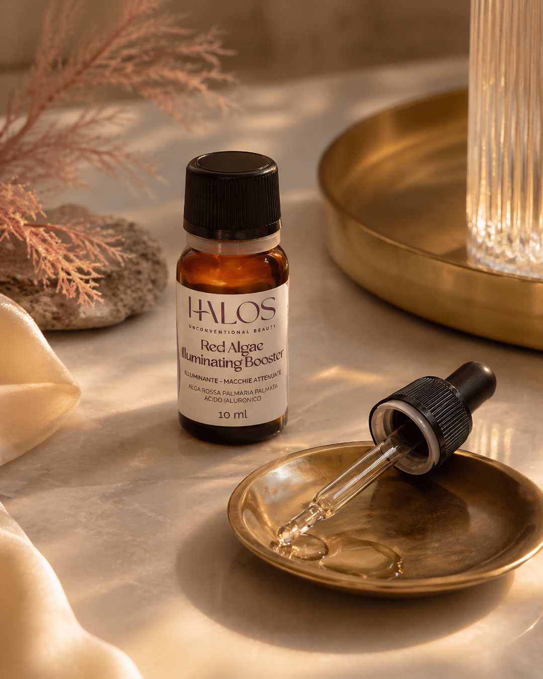 Contagocce e flacone di Red Algae Illuminating Booster su un vassoio dorato