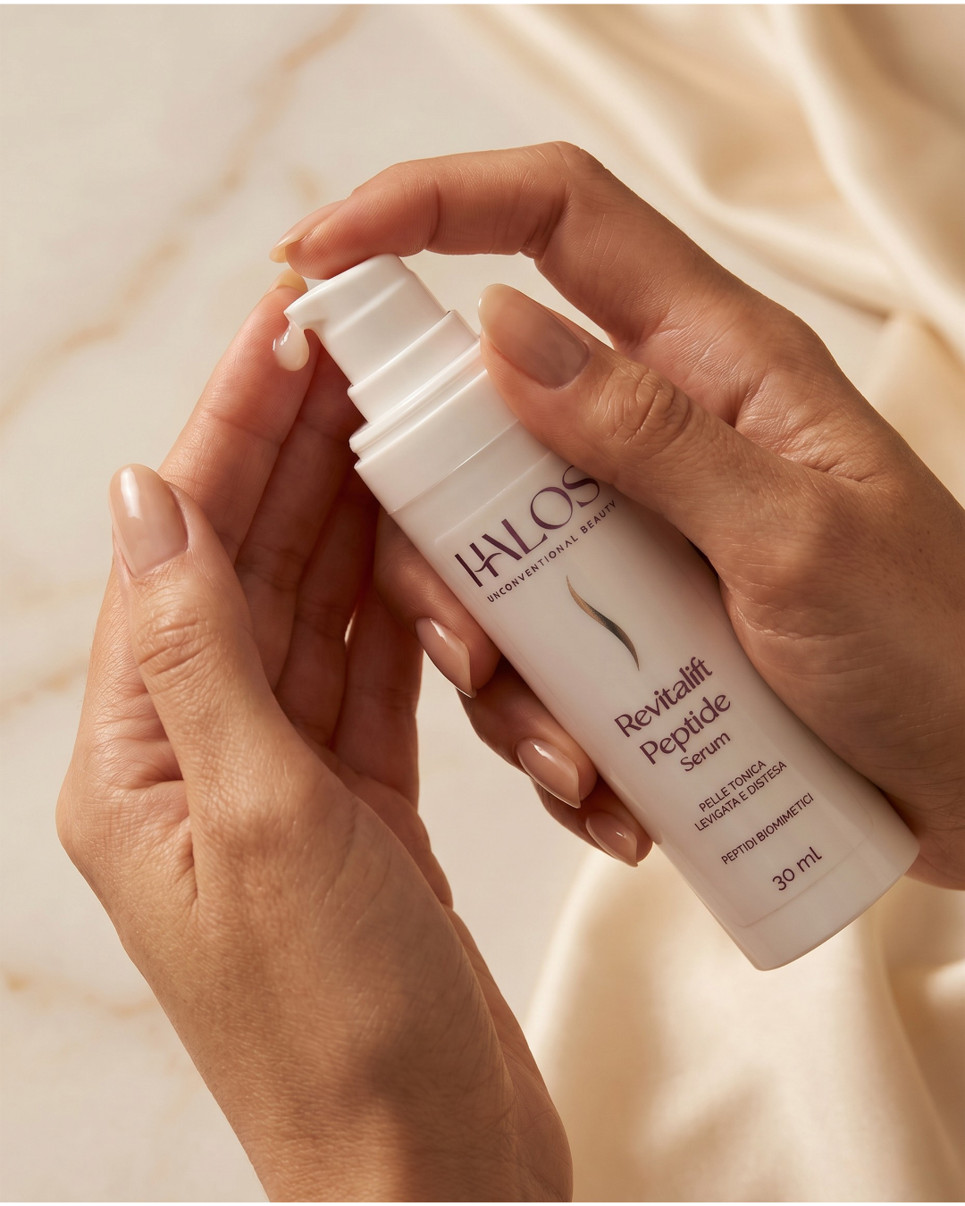 Mani che erogano Revitalift Peptide Serum dal flacone airless