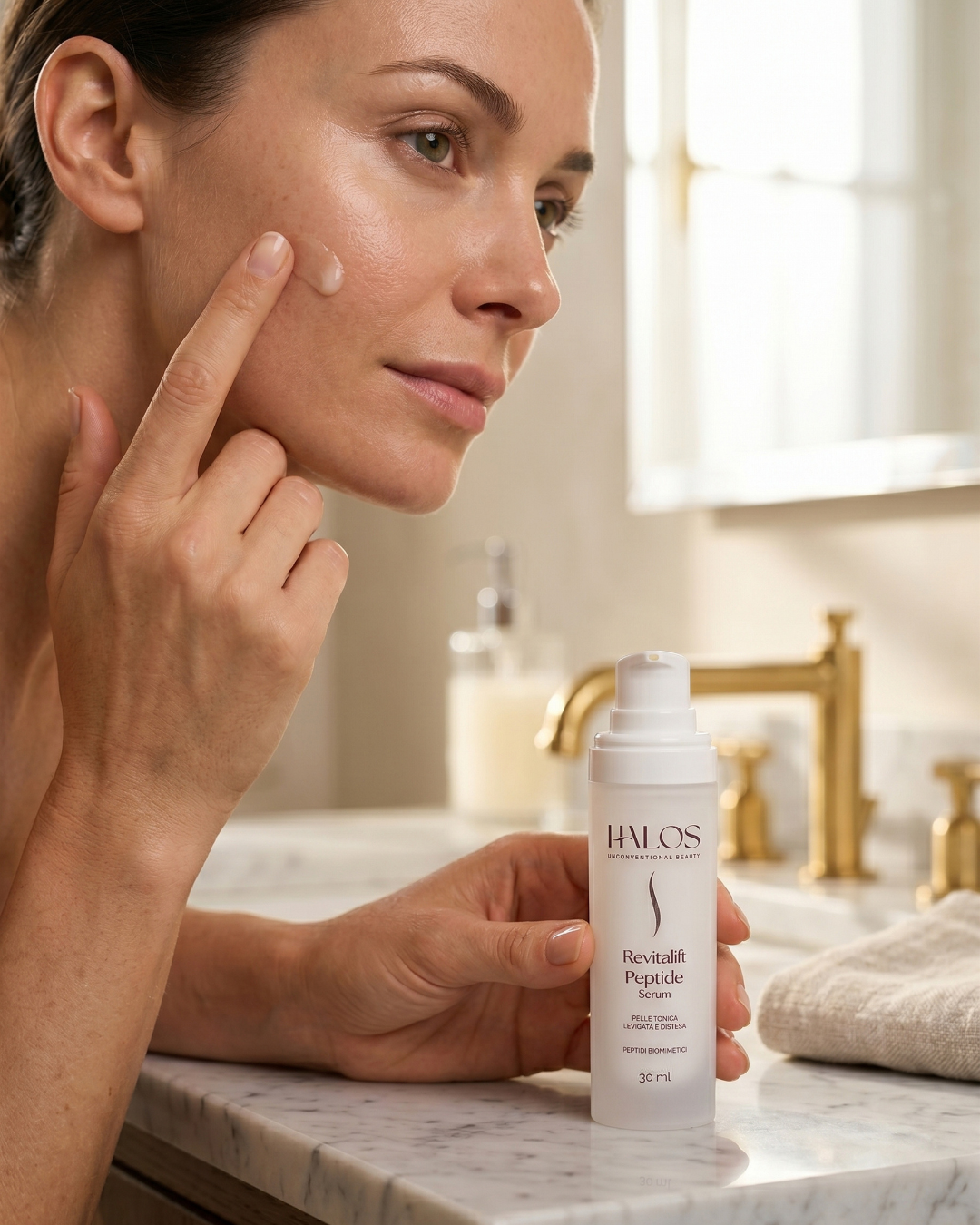 Donna che applica Revitalift Peptide Serum sulla guancia