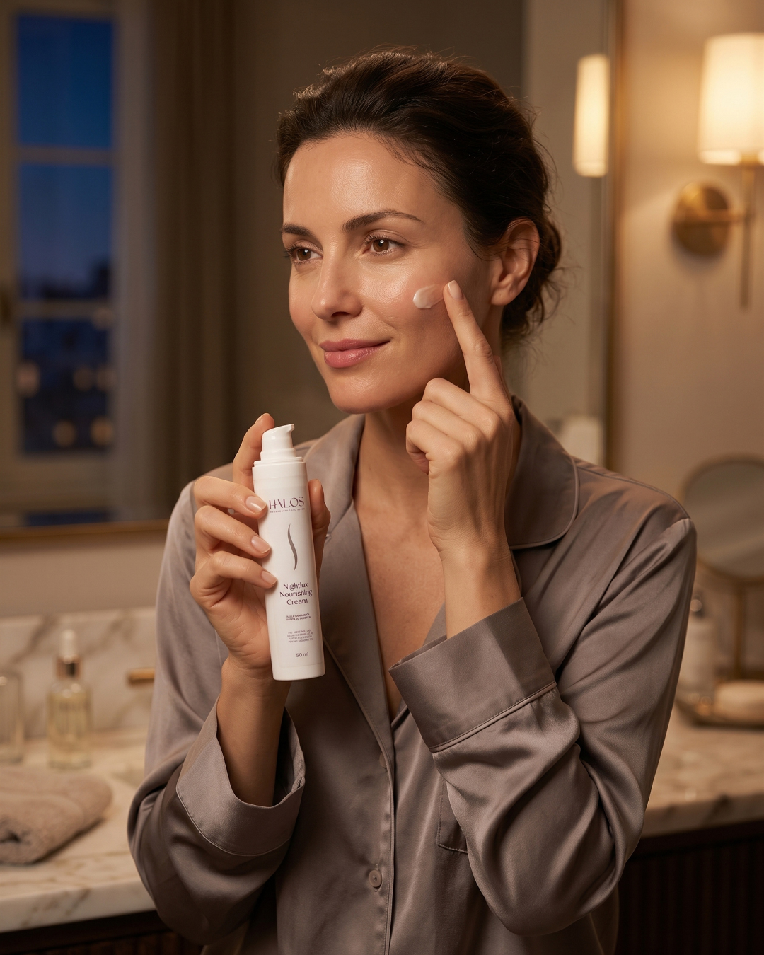 Donna che applica Nightlux Nourishing Cream sulla guancia durante la routine serale