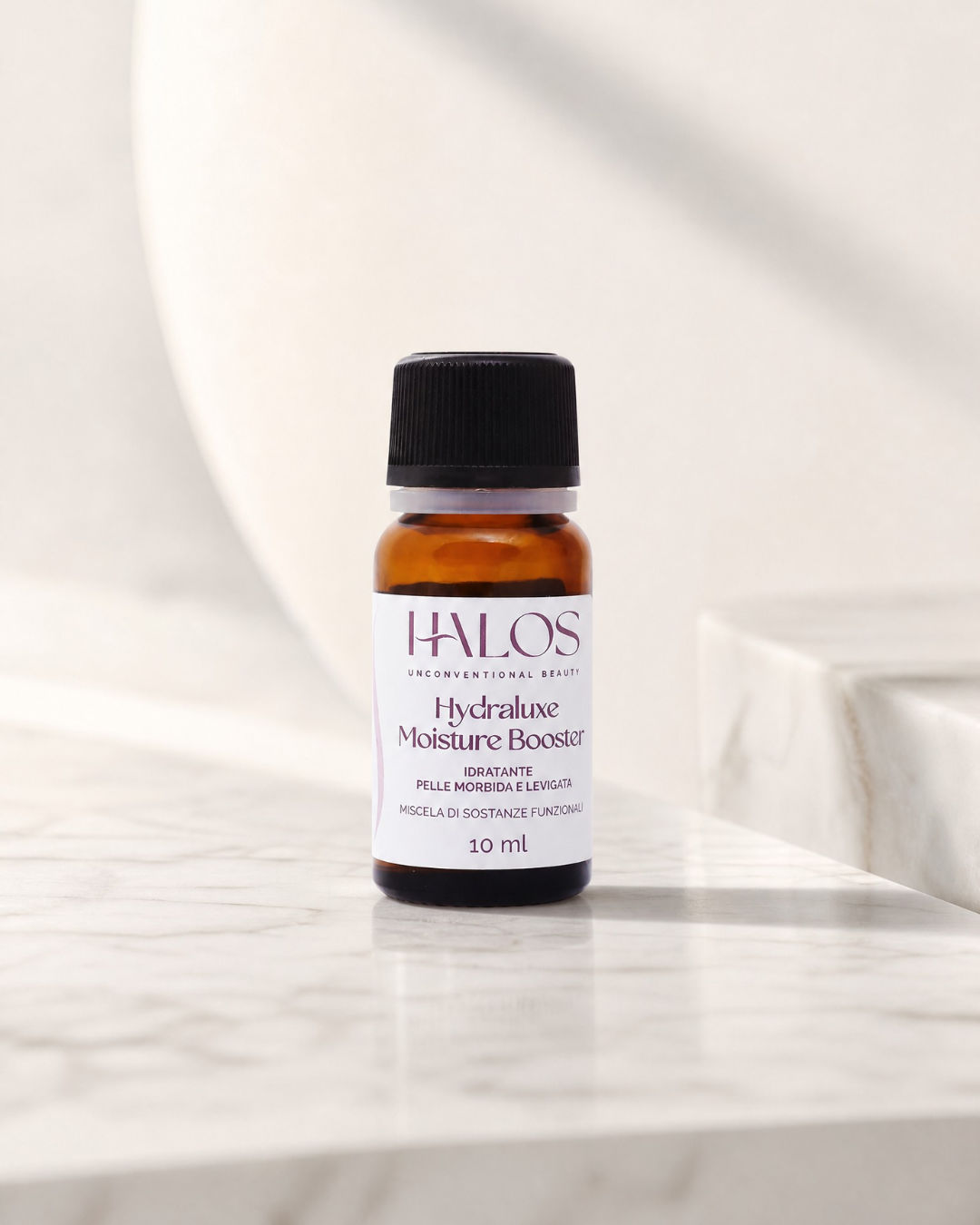 Flacone di Hydraluxe Moisture Booster Halos da 10 ml su marmo chiaro