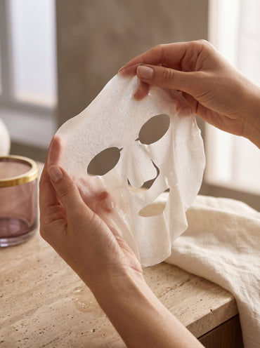 Maschera viso in tessuto Collagen Elixir aperta tra le mani